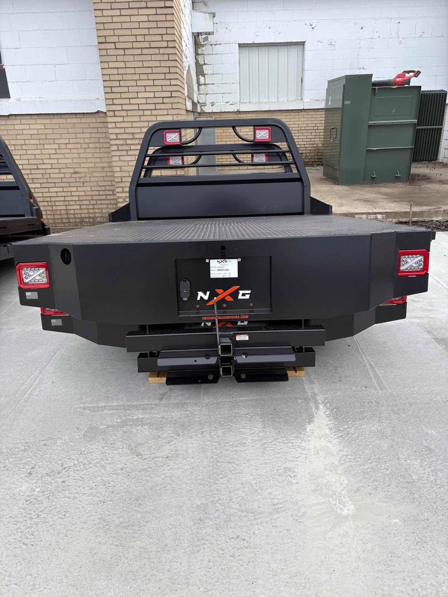 Rear view of the NXG XFD flatbed showing the recessed license plate panel, receiver hitch, and LED tail lights