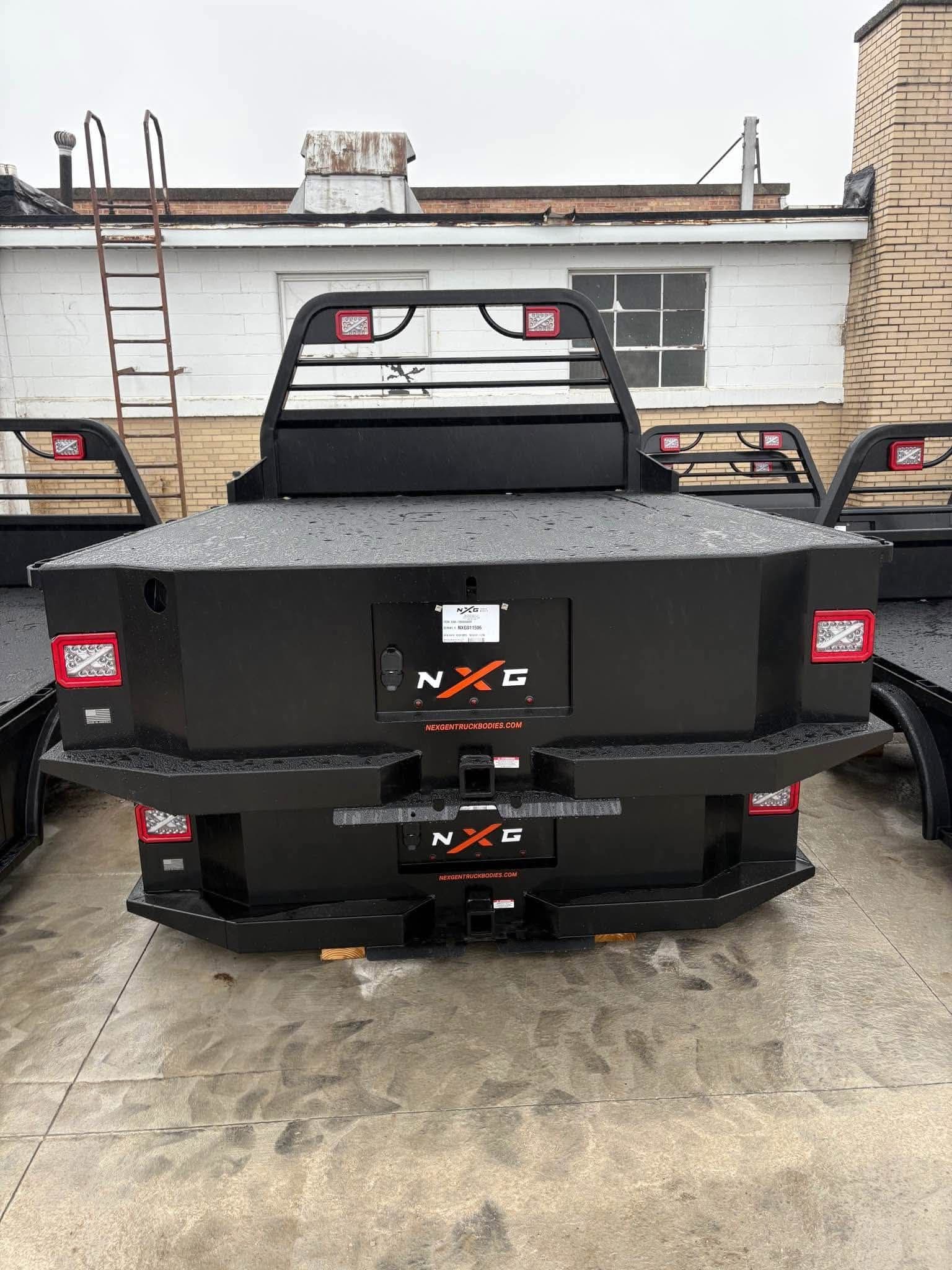 Rear view of the NXG XSD skirted flatbed showing the license plate panel, receiver hitch, and rear bumper steps