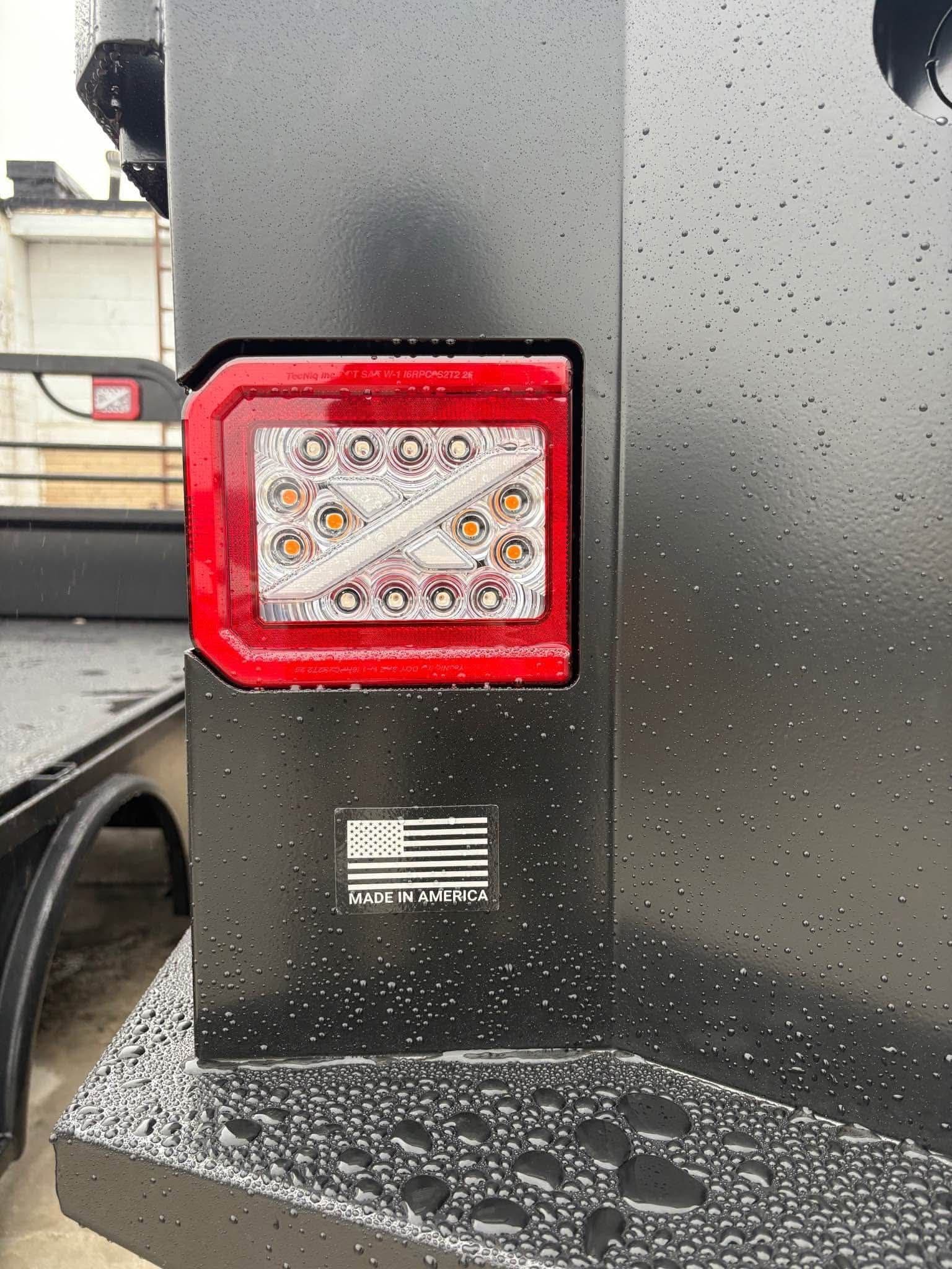 Close-up of an NXG LED tail light with amber and white lamps beside a Made in America badge