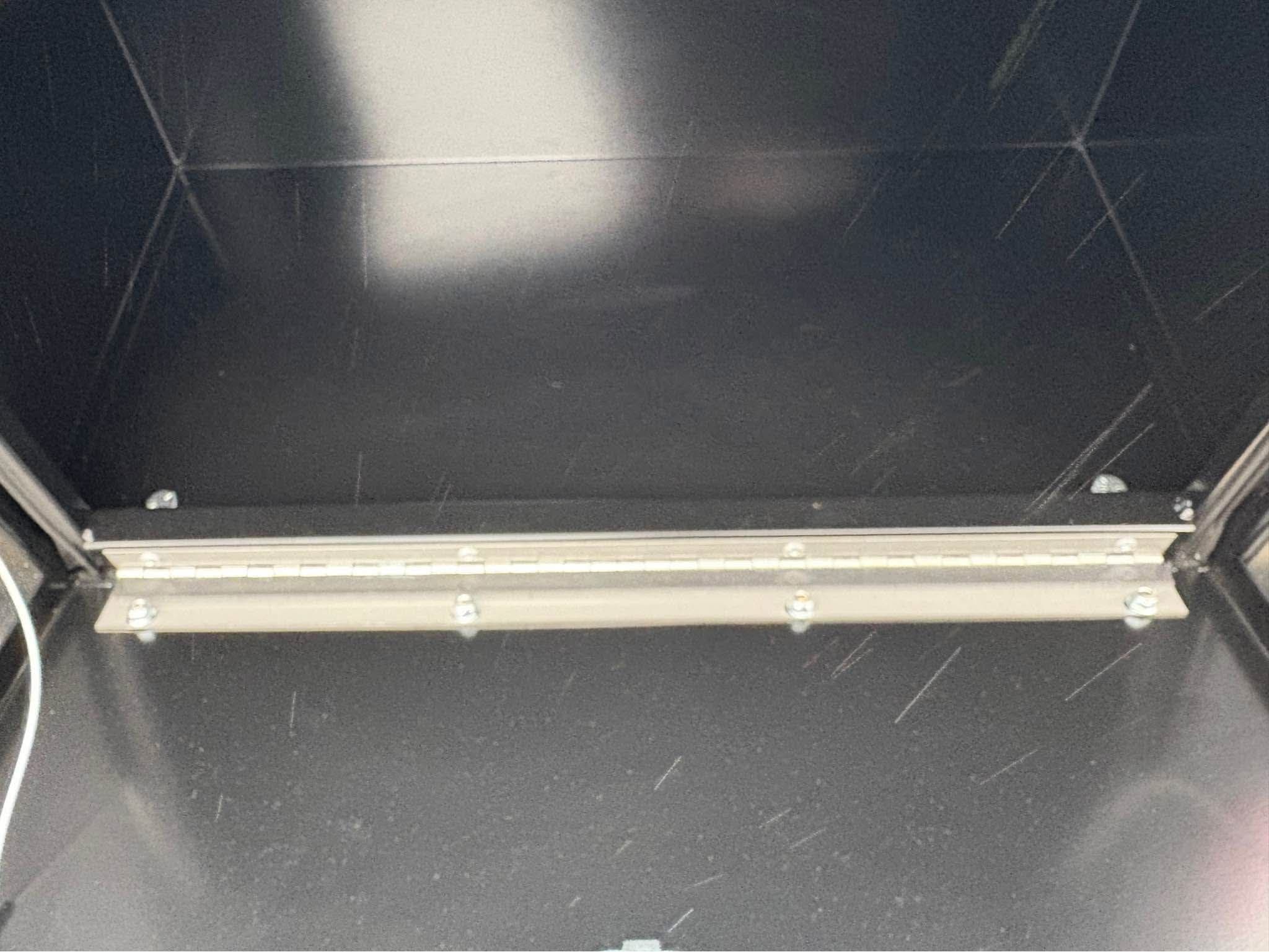 Interior of an NXG skirted flatbed toolbox compartment showing the full-length stainless steel hinge