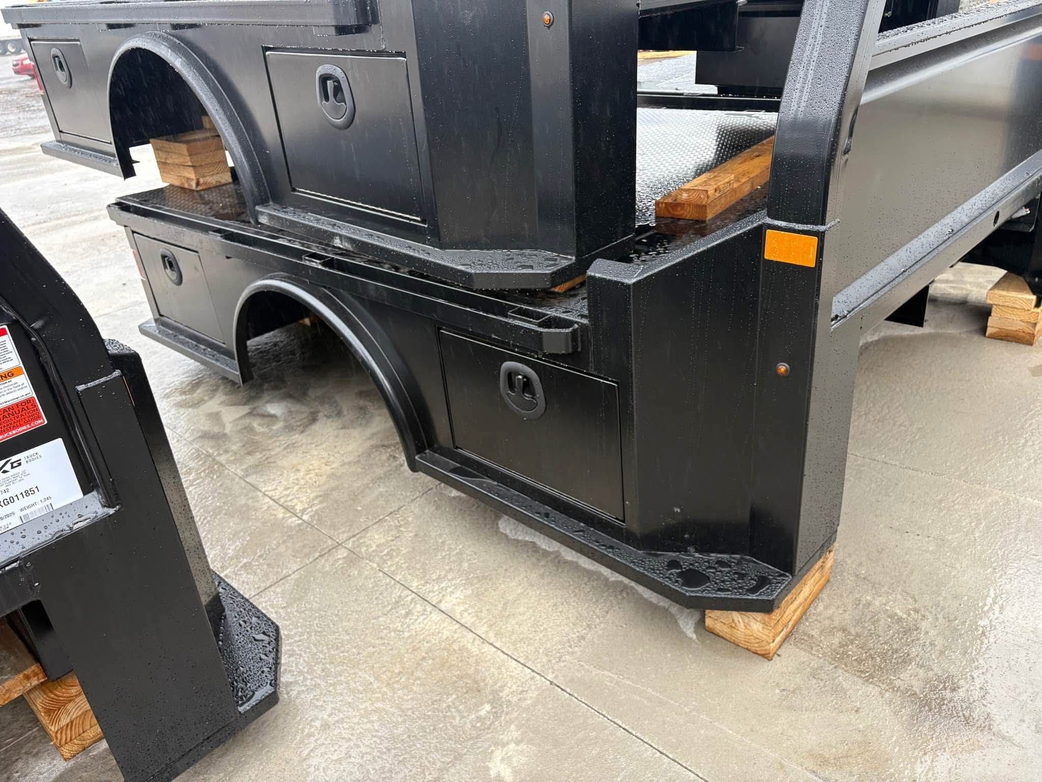 NXG XSD skirted flatbeds staged on blocks in the yard, showing the skirted compartments and fender profile